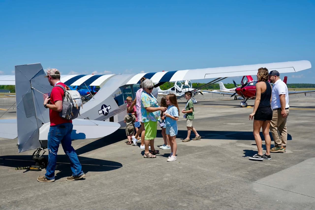 A Cessna 172 on the ramp at Grand Strand Airport with visitors gathered around it